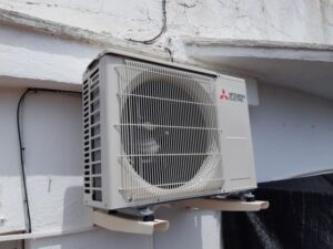Instal·lació d'unitat exterior d'aire condicionat Mitsubishi a exterior de vivenda